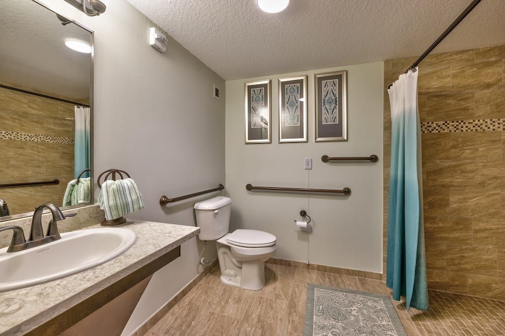 A modern bathroom with accessibility features including grab bars and a spacious layout.