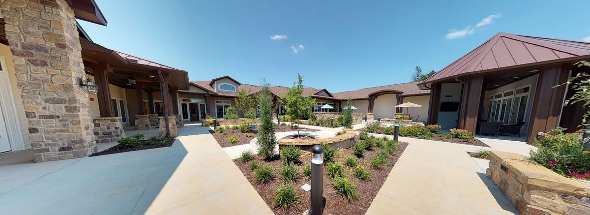 A well-maintained residential building with landscaped gardens on a sunny day.