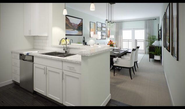 A modern open-concept kitchen and dining area featuring white cabinets and pendant lighting.