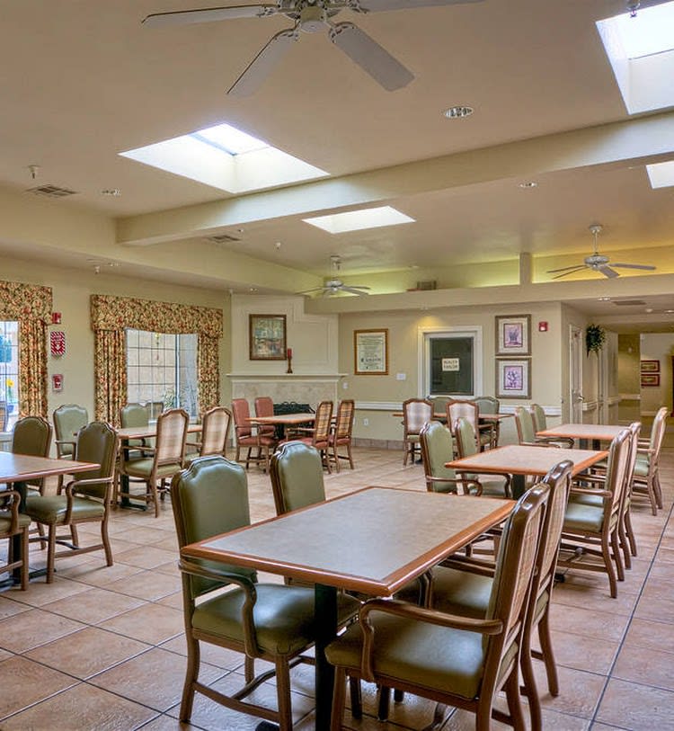 An empty dining room with tables and chairs under skylights.