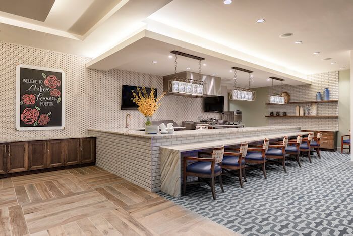 A modern restaurant interior featuring a sleek bar counter with seating.