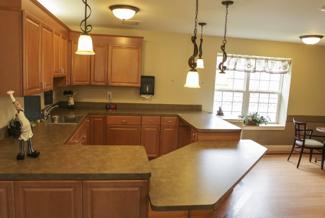 A modern kitchen with wooden cabinets, spacious countertops, and stylish pendant lighting.