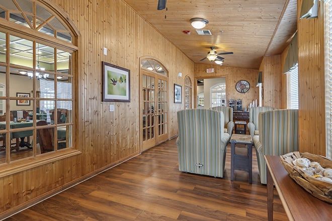 A cozy hallway with wood paneling, featuring comfortable seating and framed artwork.