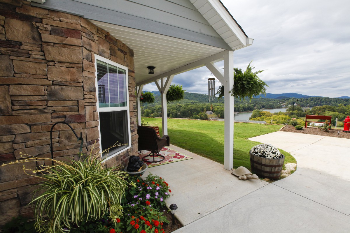 A scenic view from a cozy porch with a garden and surrounding landscape.
