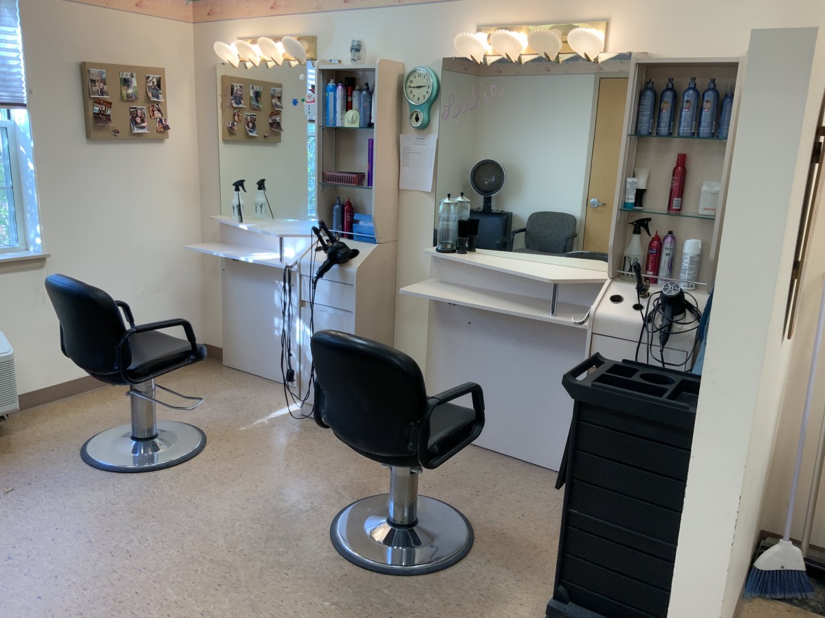A tidy hair salon interior with styling chairs and mirrors.