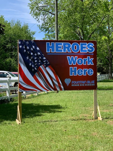 A sign declaring that 'Heroes Work Here' accompanied by an American flag.