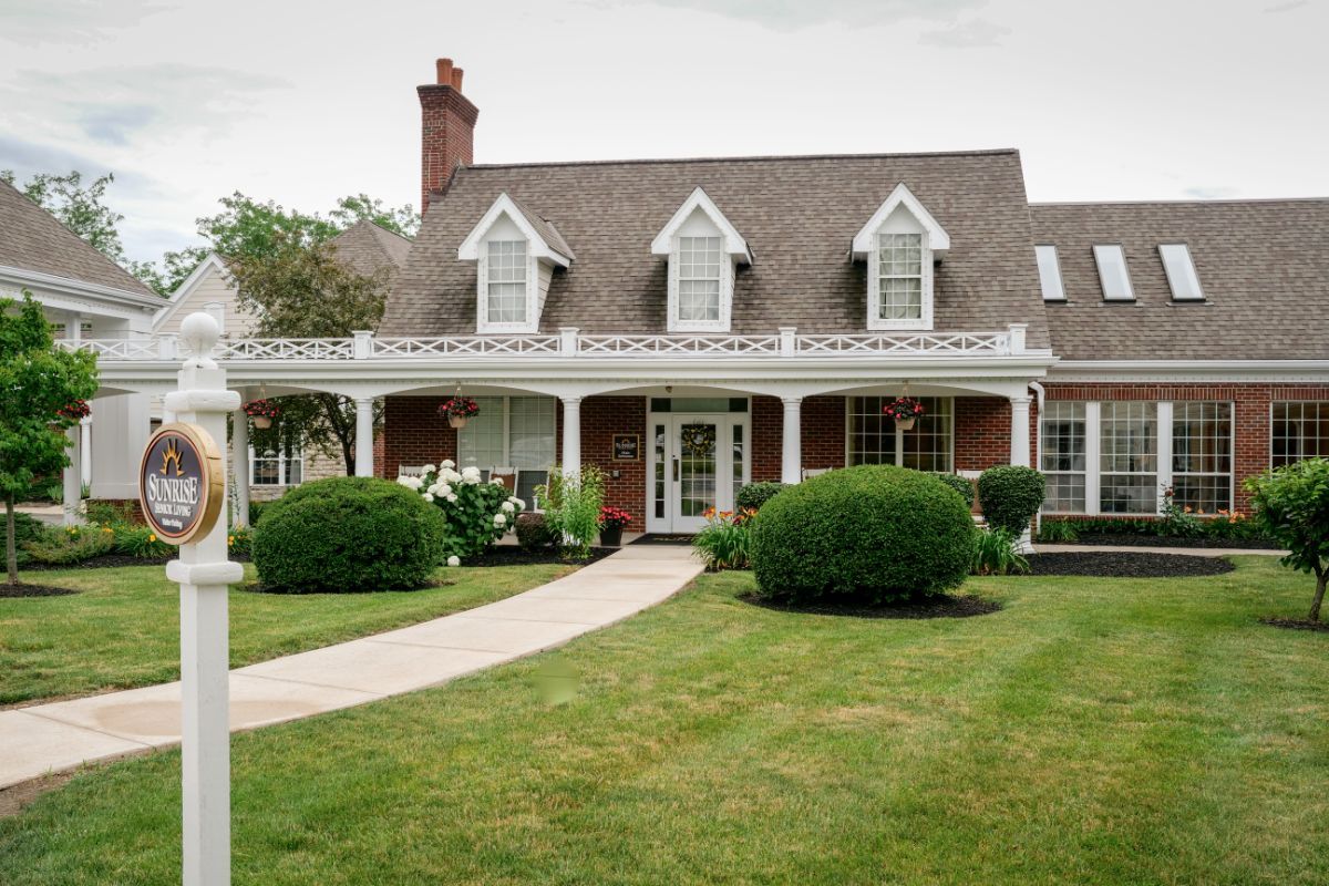 A charming suburban home with a manicured lawn and lush greenery.