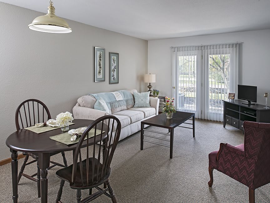 A cozy living room with a dining area, featuring a sofa, coffee table, and dining set.