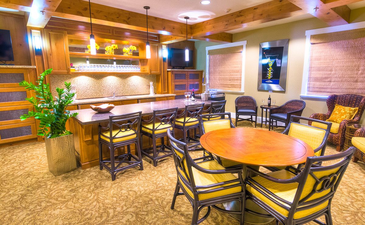 An inviting bar area with wooden furnishings and stylish lighting.