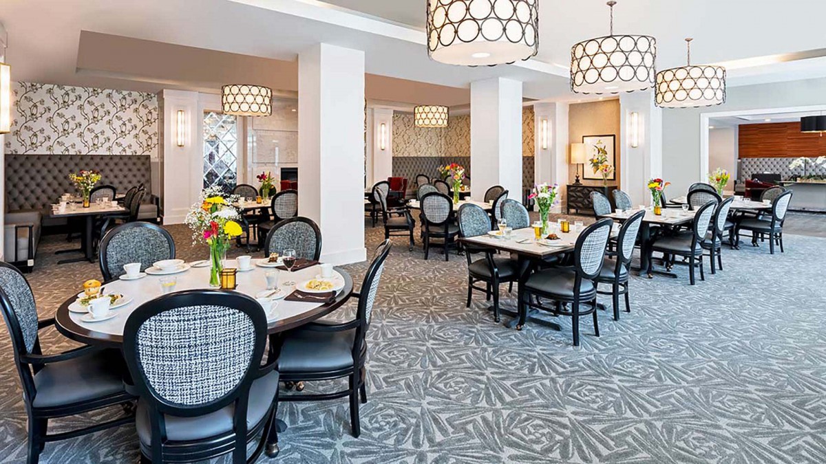 A stylish dining area with elegant tables, chairs, and modern chandeliers.