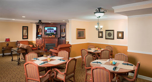 A cozy dining area featuring tables set for guests, comfortable seating, and a television.