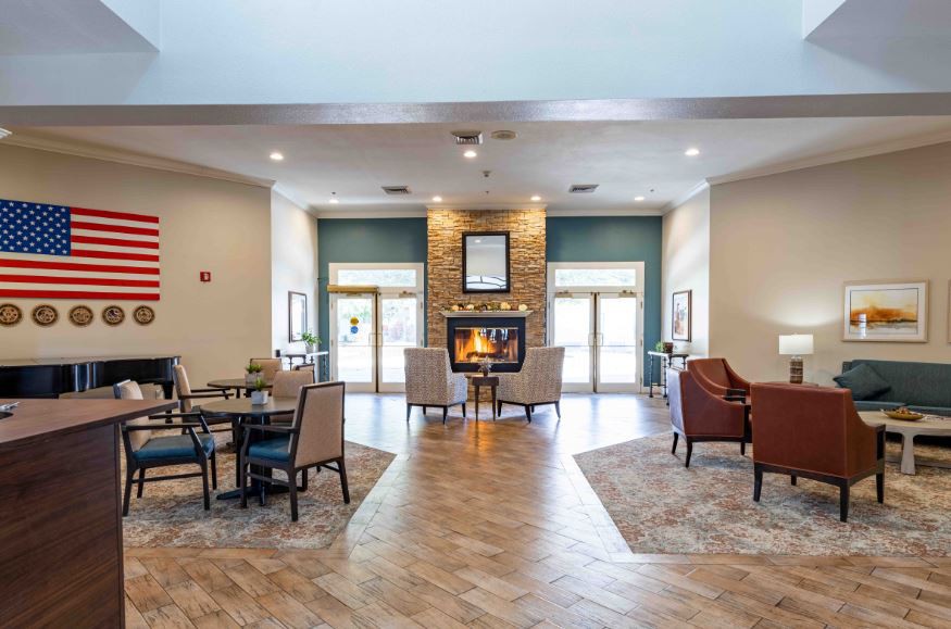 A cozy lounge area with a central fireplace and comfortable seating.