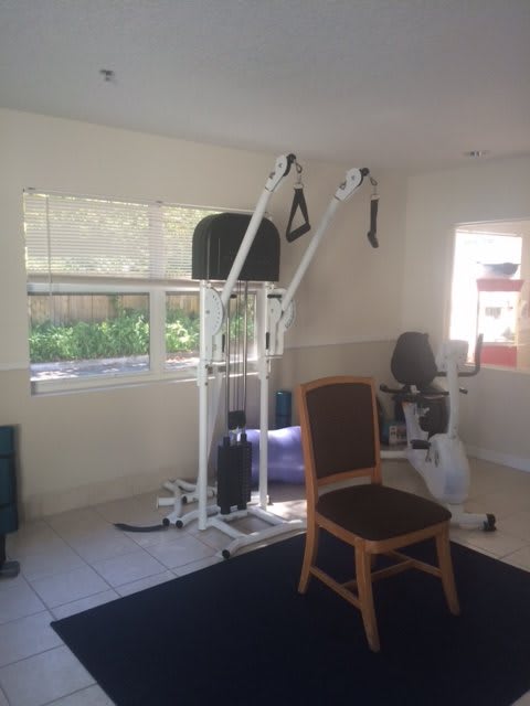 A home gym setup featuring exercise equipment and a chair.