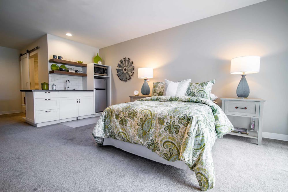 A modern and cozy bedroom featuring a stylish bed with patterned bedding, two bedside lamps, and minimalistic decor.