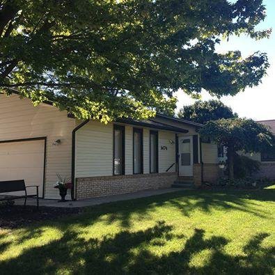 A residential house with a well-maintained yard on a sunny day.