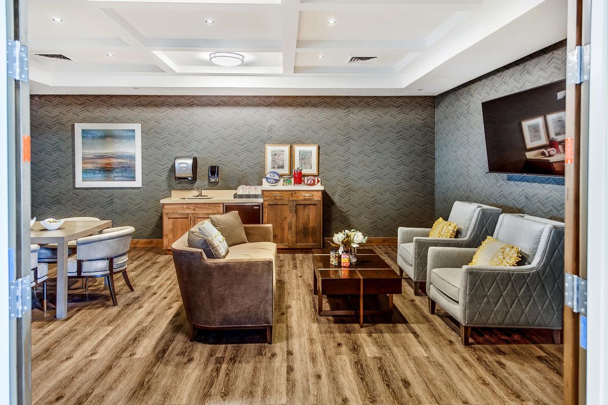 A modern lounge area featuring comfortable seating with armchairs and a coffee table on a hardwood floor.