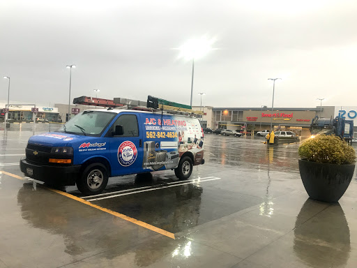 A branded van parked in a rainy shopping center parking lot.