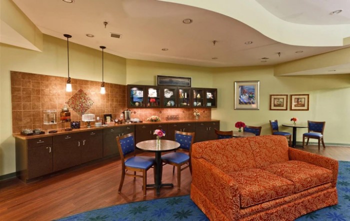 A cozy kitchen and dining area with a coffee station, warm lighting, and comfortable seating.