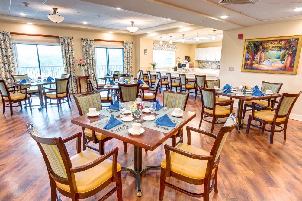An elegant dining room set with tables and chairs, featuring neatly arranged place settings.