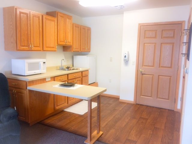 A minimalist kitchen with wooden cabinets and an island table.