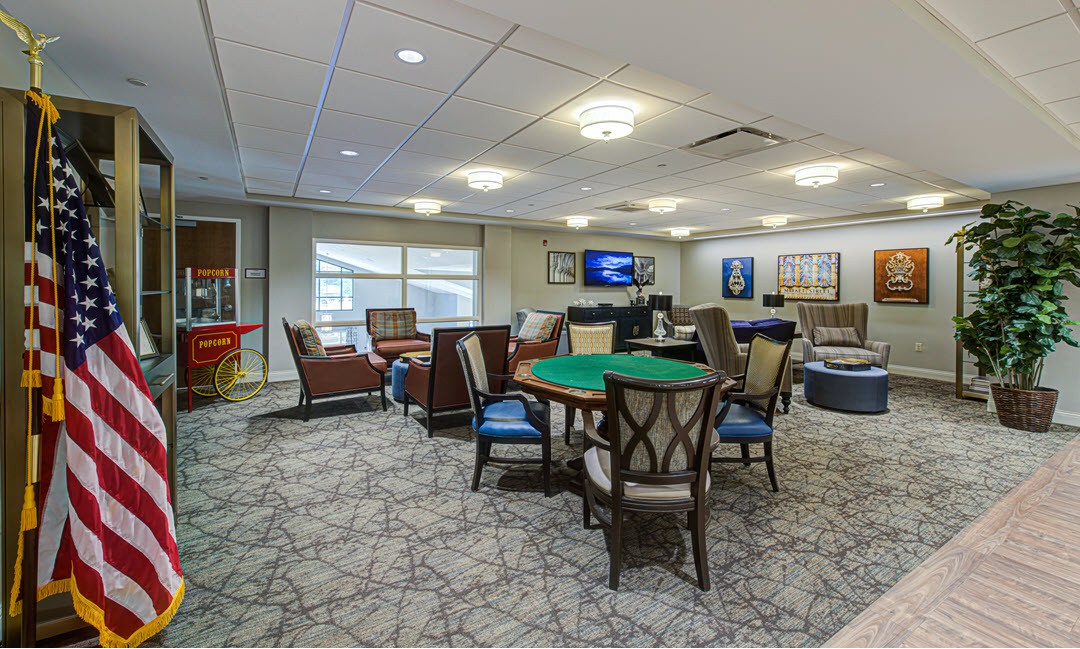A spacious lounge featuring comfortable seating, a gaming table, and a television.