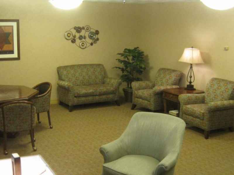 A cozy living room with sofas, armchairs, a lamp, and decorative elements.