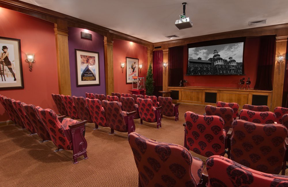 A luxurious home theater with plush seating and a large screen.
