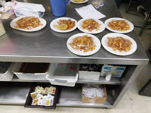 A countertop in a kitchen displaying several plates of food, ready for serving.