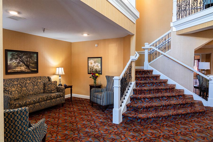 A cozy interior space featuring a staircase and comfortable seating.