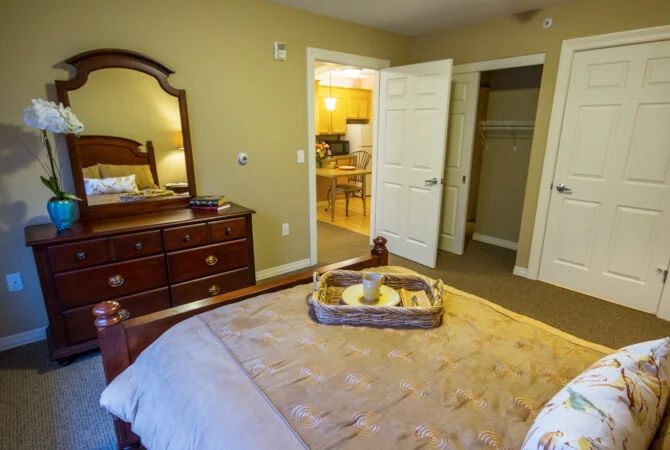 Cozy bedroom with a dresser and an open door leading to another room.
