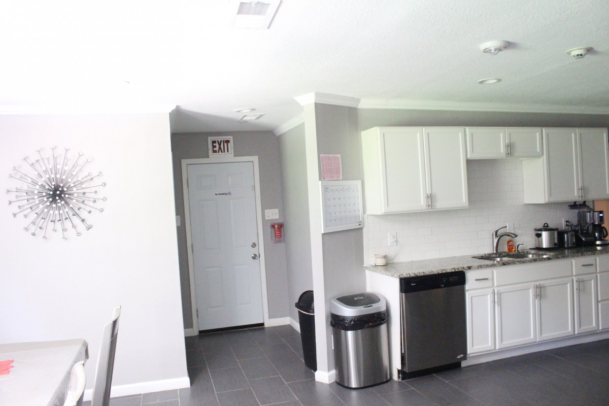 A modern kitchen with white cabinets and stainless steel appliances.