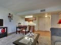 A cozy apartment interior featuring a combined living and dining area with an open kitchen.