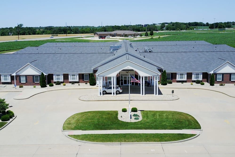 Aerial view of a large building with a landscaped entrance and circular driveway.