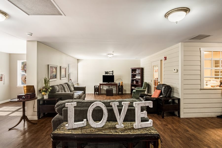 A cozy living room with elegant furniture and a decorative 'LOVE' sign.