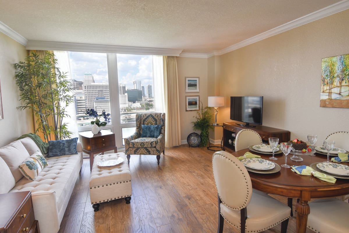 A modern living room with elegant furniture and a city view from the window.