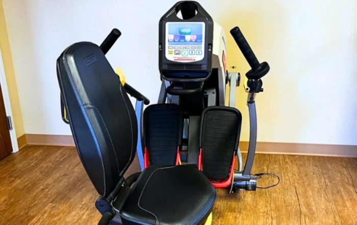 A recumbent stepper machine designed for indoor workouts, featuring a comfortable seat and digital display.