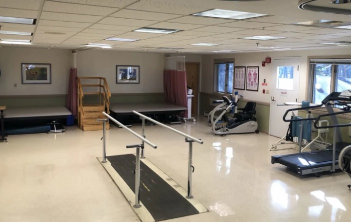 A well-equipped rehabilitation and physical therapy room with various exercise equipment.