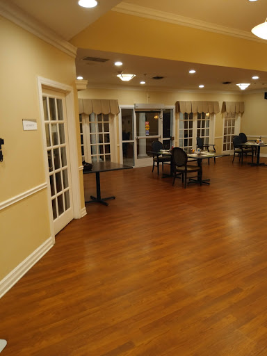 A spacious dining area with wooden flooring and cozy seating arrangements.