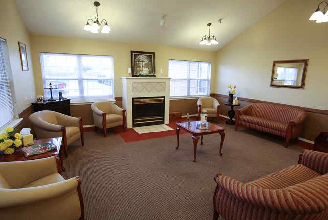 A cozy living room with sofas, chairs, and a central fireplace.