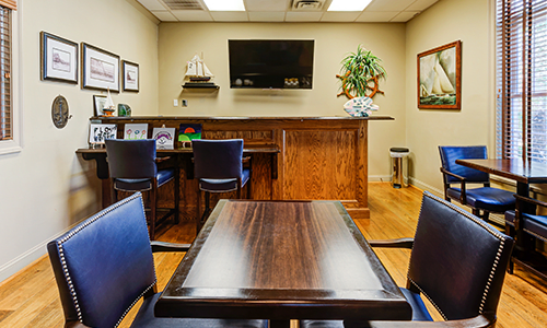 A well-arranged meeting room with a wooden table, chairs, and a television mounted on the wall.