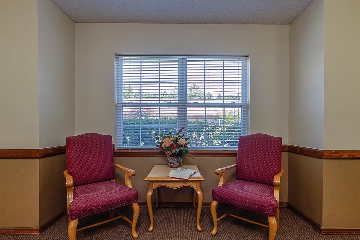 Cozy seating area with two chairs and a table by the window.