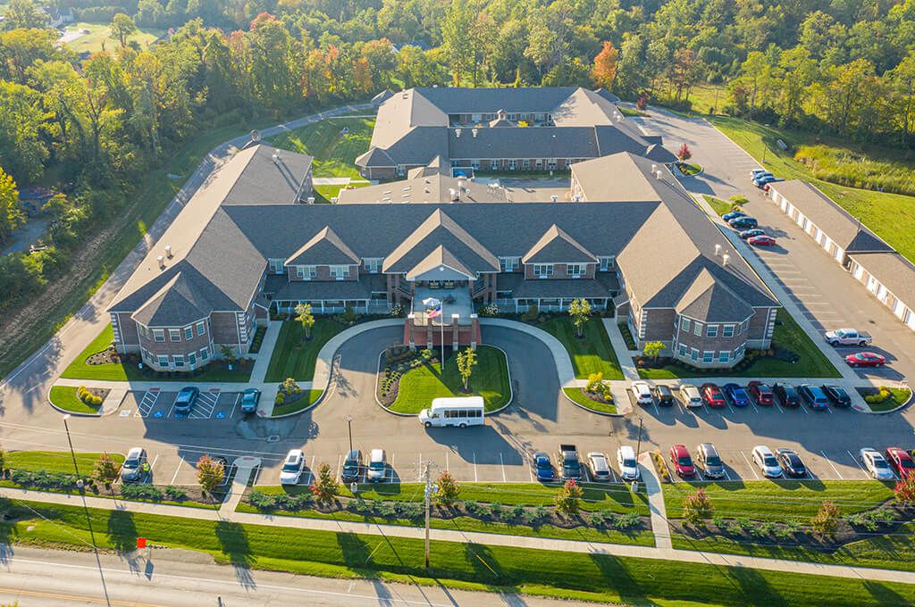 An aerial view of a large, symmetrical building with a parking lot and surrounding greenery.