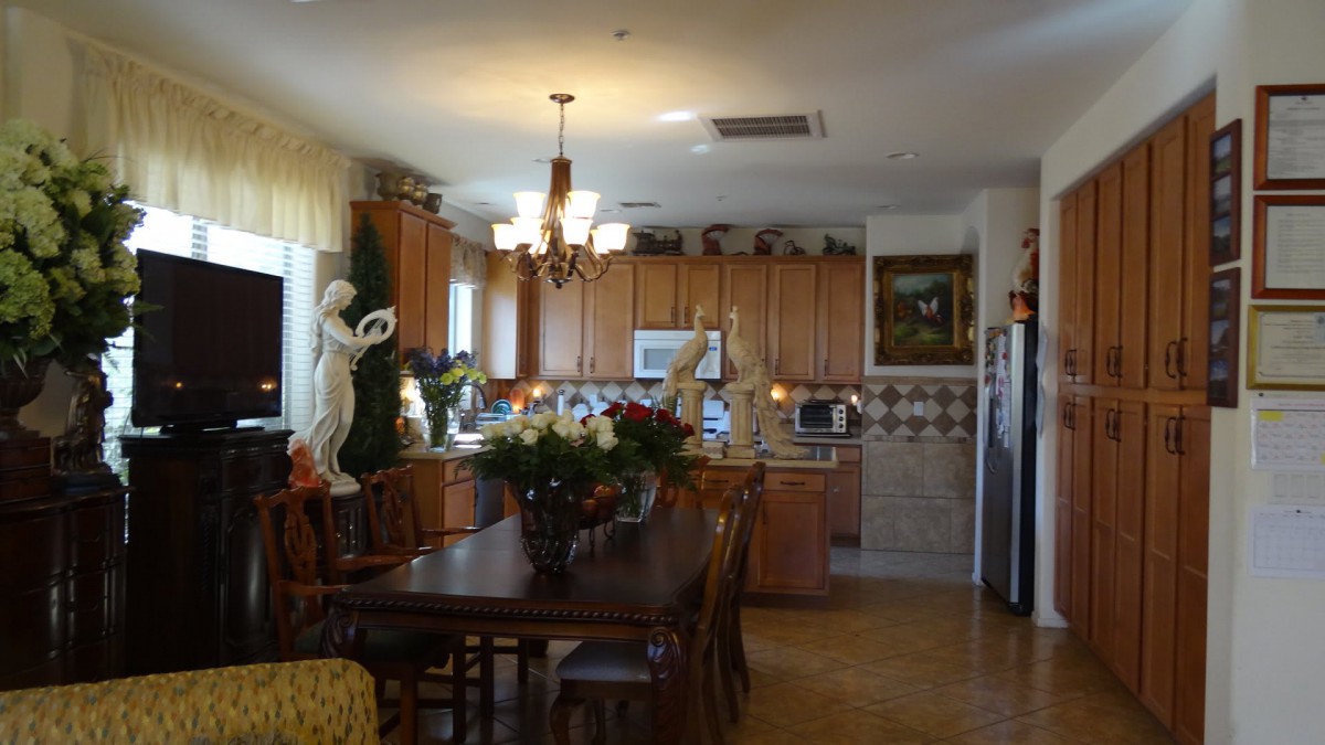 A spacious kitchen with wooden cabinets, a dining table set, and elegant decor.