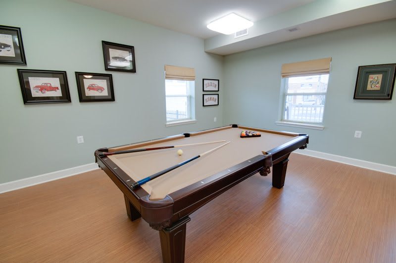 A cozy game room featuring a billiards table with cue sticks and balls ready for a game.