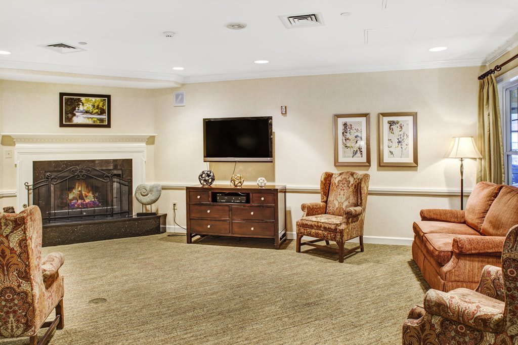 A cozy living room with a fireplace, television, and comfortable seating.