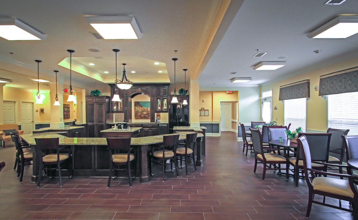 A spacious kitchen and dining area featuring a central counter with bar stools and elegant pendant lighting.