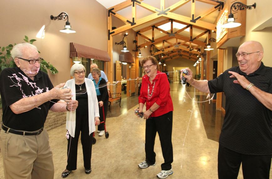A group of elderly people having a joyful gathering indoors.