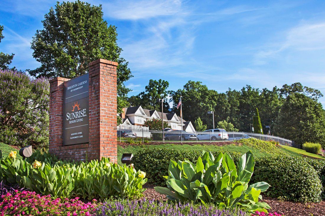 Entrance to Reynolda Village with landscaped gardens and surrounding trees.