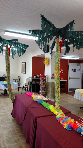 A festive indoor setting decorated with vibrant palm tree props for a celebration.