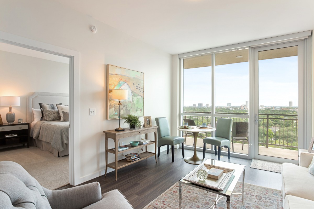 A modern and bright apartment living room with contemporary furniture and large windows.
